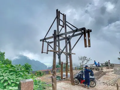 Houten Akha-schommelraam op een heuveltop in het dorp Pha Hee, met bergen erachter