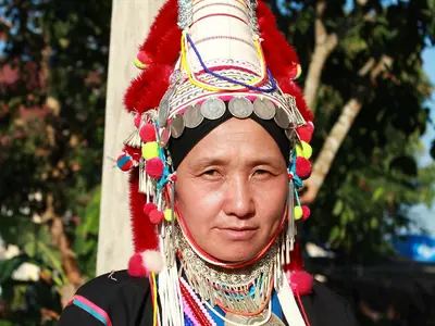 Een Akha-vrouw in de traditionele met zilver versierde hoofdtooi in Chiang Rai