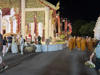 Monks and devotees with floral offerings at Wat Chedi Luang during the Asalha Puja ceremony