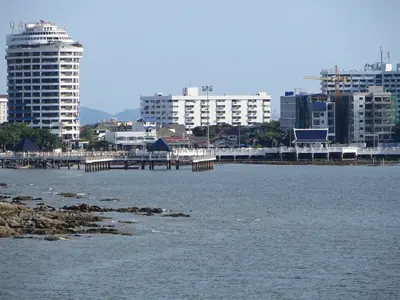 Bang Saen waterfront with high-rise buildings and rocks in the shallows