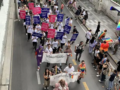 Marchers with banners and rainbow flags fill the street at Bangkok Pride 2024