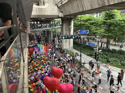 Rainbow flags and red heart balloons seen from a balcony at Bangkok Pride 2024