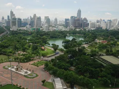 Aerial view of Lumphini Park with its lake and the Bangkok skyline