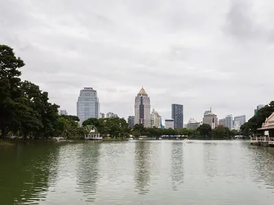 Calm lake at Lumphini Park in Bangkok with skyscrapers in the distance