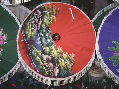 Hand-painted paper umbrellas in green, red and blue with flowers, labelled Bo Sang, Chiang Mai