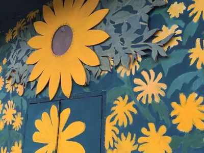 Yellow flower decorations on a blue wall at Mae U Kho, Khun Yuam district