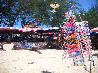 Strandverkopers met parasols en hangende souvenirs op het strand van Cha-am in 2010