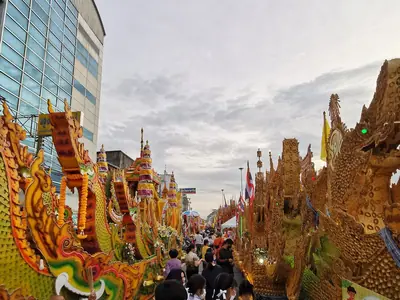 A tall golden Chak Phra float passing buildings in Surat Thani (15 October 2022)