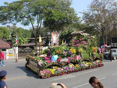 Een praalwagen met een tuin van bloemen en planten in een straat in Chiang Mai tijdens het bloemenfestival