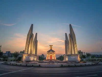 Het Democratiemonument in Bangkok bij zonsondergang, met zijn vier vleugels en centrale sokkel