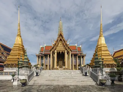 Binnenplein van Wat Phra Kaew met gouden chedi's en de rijk versierde hal in het Grote Paleis in Bangkok