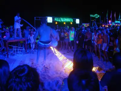 A performer jumping through a burning skipping rope at the Full Moon Party (2016)