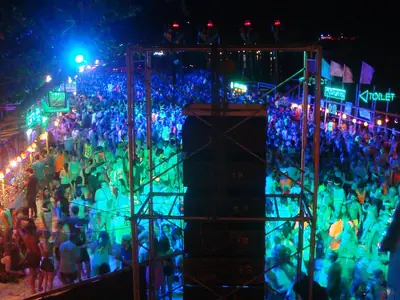 Party crowd and sound towers with colourful lighting at the Full Moon Party (2015)