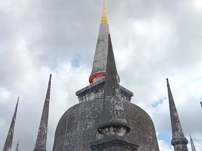 The main pagoda of Wat Phra Maha That in Nakhon Si Thammarat against a cloudy sky