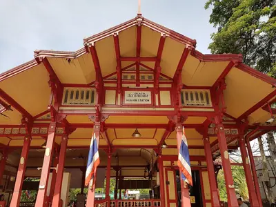 Hua Hin railway station's red-and-yellow wooden royal pavilion with Thai flags