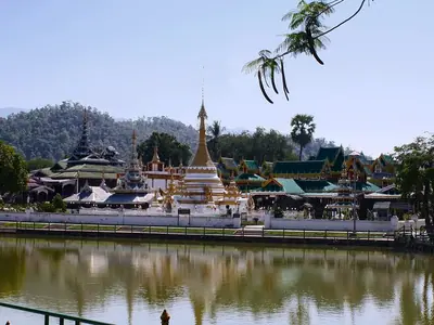 Wat Jong Kham beside its lake in Mae Hong Son, with trees and hills behind