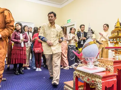 Thai community members celebrating the King's birthday with a monk and a decorated altar, in Dublin, Ireland (2014)