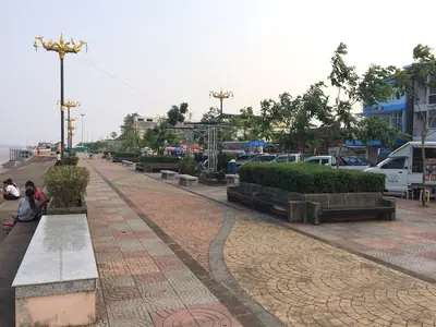 Paved riverside promenade along the Mekong in Nakhon Phanom with benches and lampposts