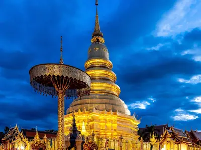 Golden chedi and umbrella-shaped offering stand at Wat Phra That Hariphunchai, Lamphun