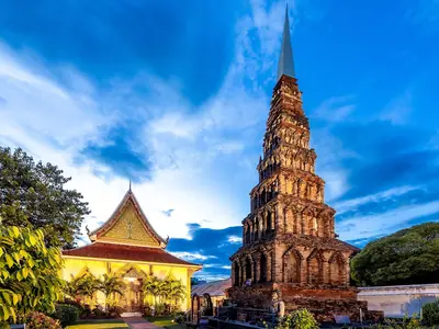 Tiered brick chedi next to a temple hall at Wat Phra That Hariphunchai, Lamphun