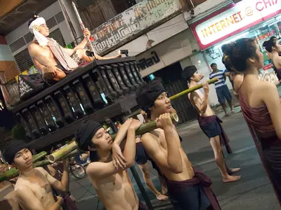 Parade float with a musician and lanterns on a Chiang Mai street during Loy Krathong