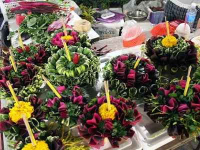 Rows of finished banana-leaf krathongs with flowers on a market stall for Loy Krathong (2015)