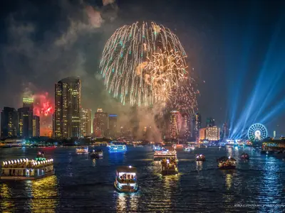 Fireworks burst over the Chao Phraya River and the skyline of Bangkok on New Year's Eve 2013