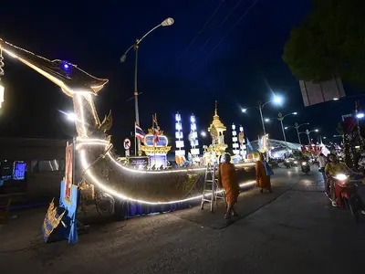 Een met lichtslingers versierde boot gloeit 's nachts op straat tijdens het Ok Phansa-festival in Thailand
