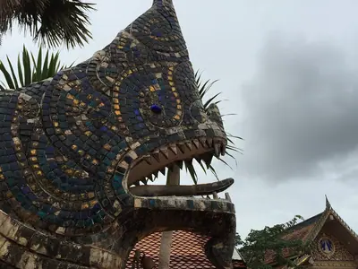 Carved dragon-headed building at Wat Phon Chai in Dan Sai, Loei, under a cloudy sky