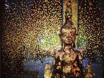 Golden Buddha image glowing with golden light at a temple in Dan Sai