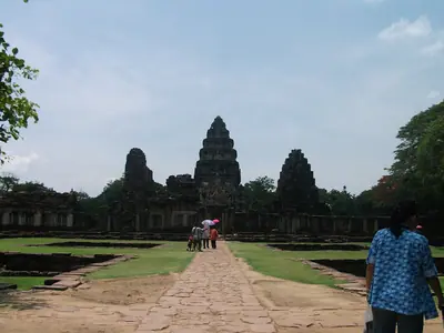 Visitors walking along the stone causeway towards the Phimai sanctuary