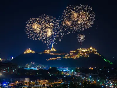 Fireworks burst in the night sky above the lit hilltop of Phra Nakhon Khiri (Khao Wang) in Phetchaburi