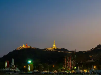 The Khao Wang hilltop with golden stupas lit at dusk in Phetchaburi