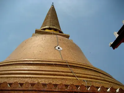 The great orange bell-shaped dome of Phra Pathom Chedi against a blue sky