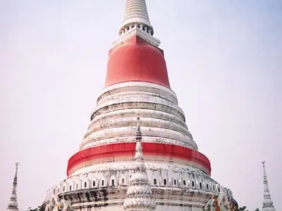 The white chedi of Wat Phra Samut Chedi with a red-wrapped upper part