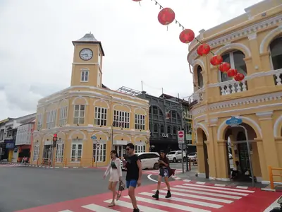 The clock tower and yellow Sino-Portuguese buildings in Phuket Old Town with red lanterns