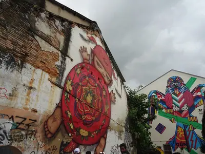 Street-art murals on old walls in Phuket Town, including a red circular design