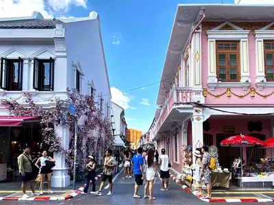 Soi Rommanee in Phuket Old Town with pastel shophouses and shoppers