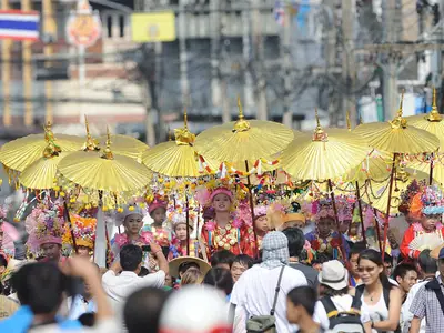 Crowd under golden parasols in the Poi Sang Long procession