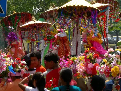 Richly dressed novices under golden parasols in the Poy Sang Long procession in Chiang Mai