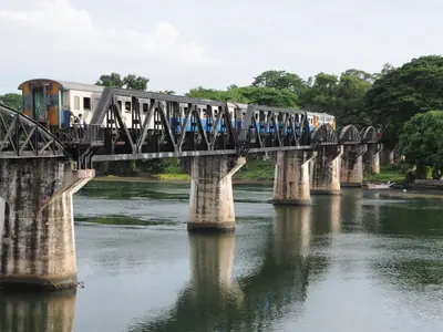 The steel truss Bridge over the River Kwai in Kanchanaburi with a train crossing