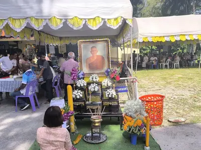 People kneeling with offerings in a decorated area during the Sat Duan Sip festival in southern Thailand