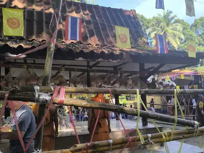 A temple fair scene with stalls and offerings during Sat Duan Sip in southern Thailand