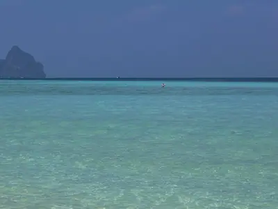 Clear turquoise shallows and a sandy shore on Ko Kradan, Trang