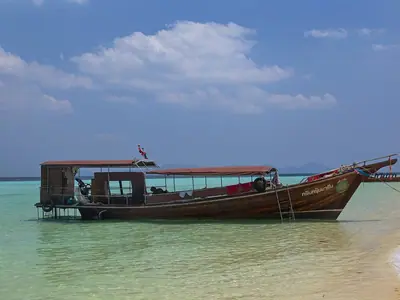 A wooden long-tail boat resting in the shallows off Ko Kradan, Trang