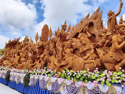 A float of Wat Phra That Nong Bua with intricately carved wax figures and flowers at the Ubon Candle Festival (July 2026)
