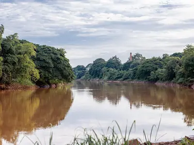 The Nan River flowing between green banks in Uttaradit