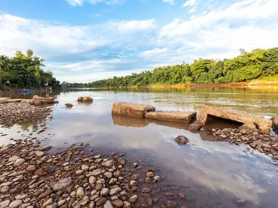 Rocks and shallow water in the Nan River at Uttaradit under a blue sky