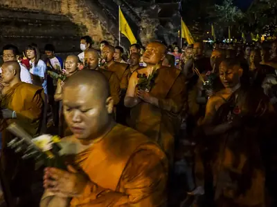 A monk with devotees making merit at Wat Chedi Luang in Chiang Mai on Visakha Bucha day