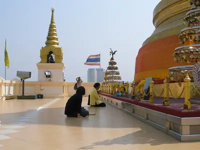 Visitors at the top of the Golden Mount at Wat Saket in Bangkok, with chedis and Thai flags